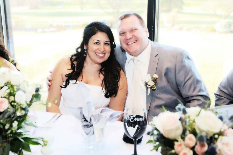 photo of the bride and groom smiling after their wedding toasts while sitting at the bridal party table at Tamaron Country Club