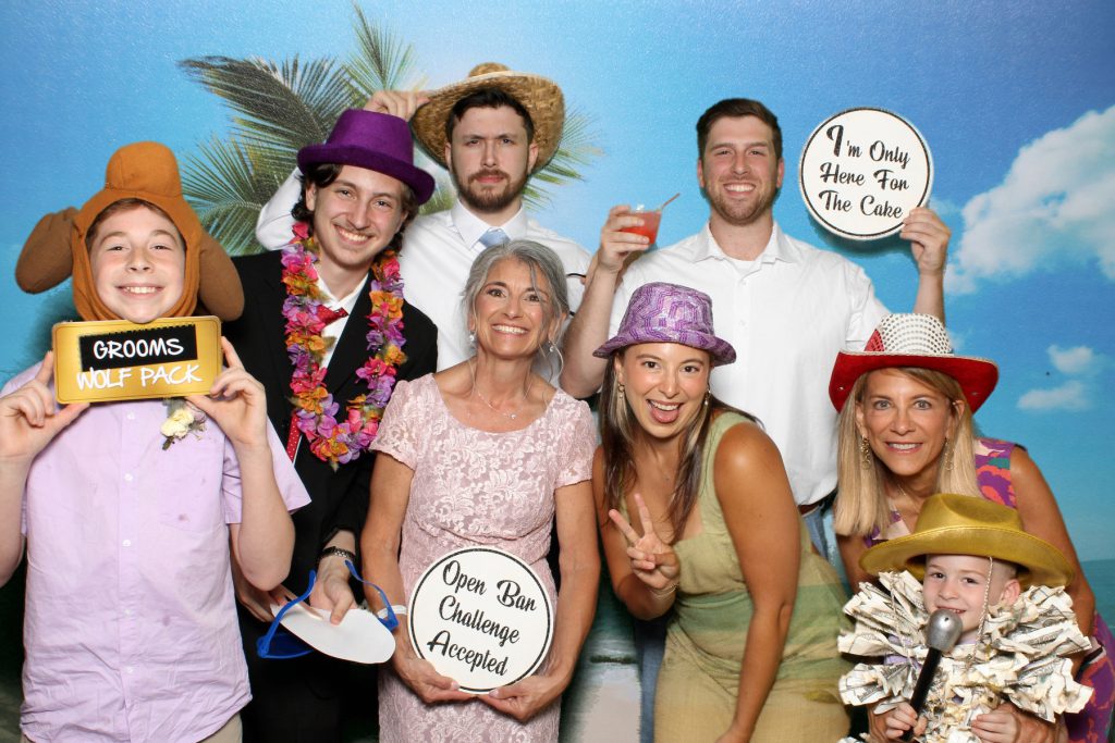 family of the groom posing with props for a photo booth photo