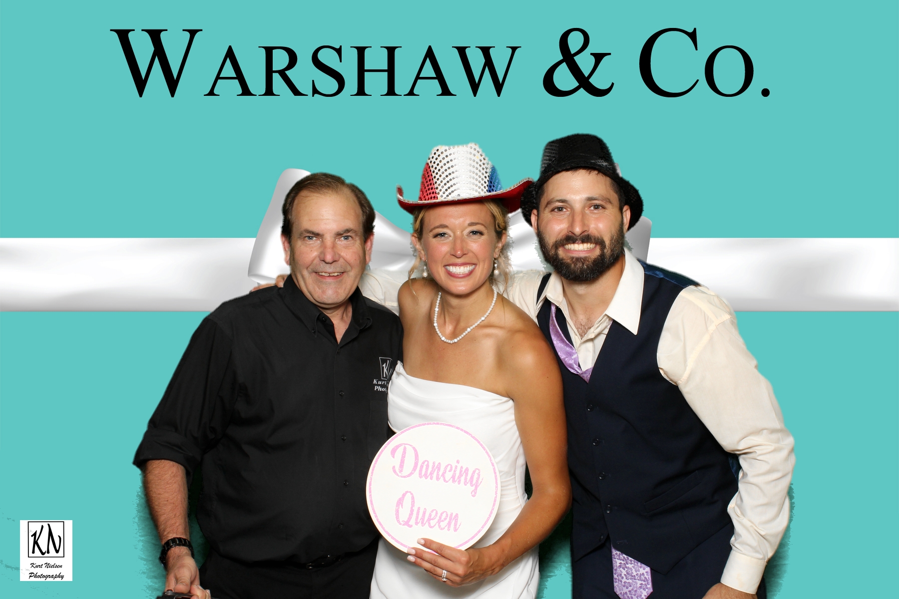 Kurt Nielsen of Kurt Nielsen Photography posing with the bride and groom in the photo booth