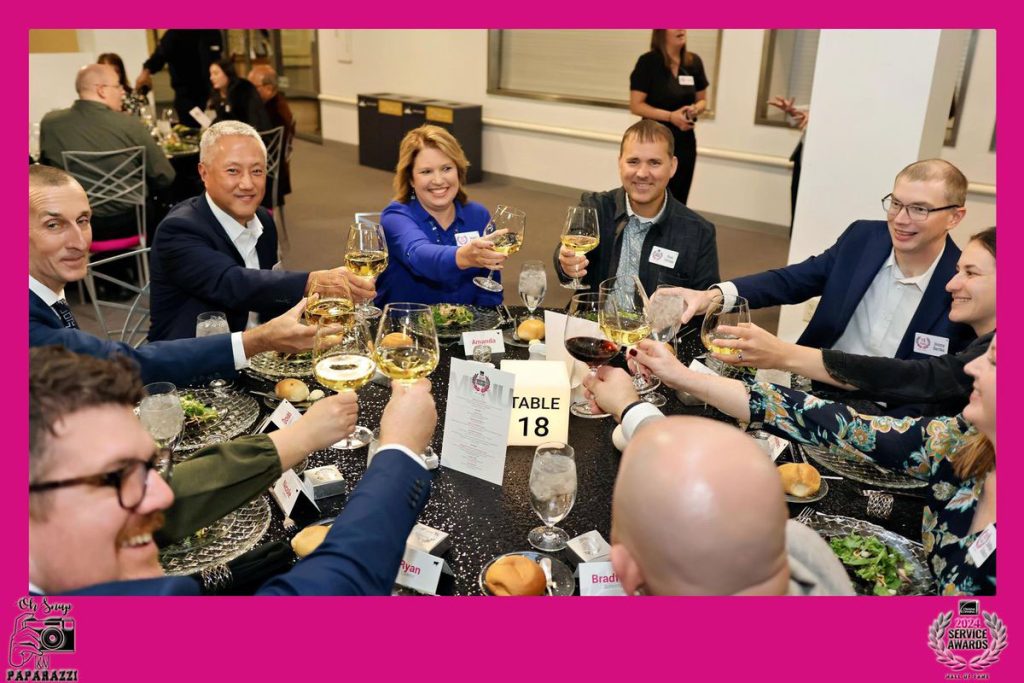 guests sitting down to dinner and making a toast at the employee appreciation dinner