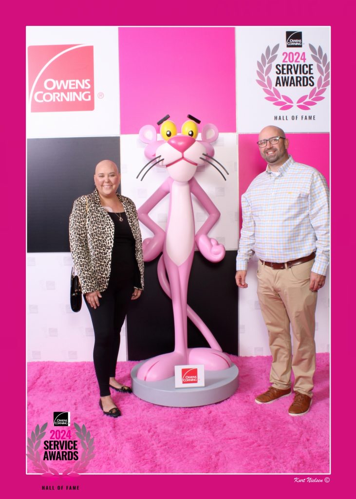 photo of a couple posing with a giant pink panther bobblehead at an owens corning headquarters employee appreciation party