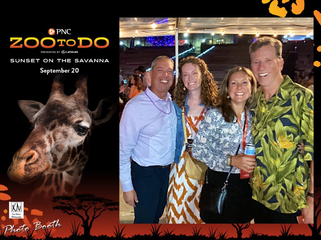 Kori  Kawczynski and her husband and another couple stop to pose for a photo with our Walk-About Social Booth at the Toledo Zoo to Do