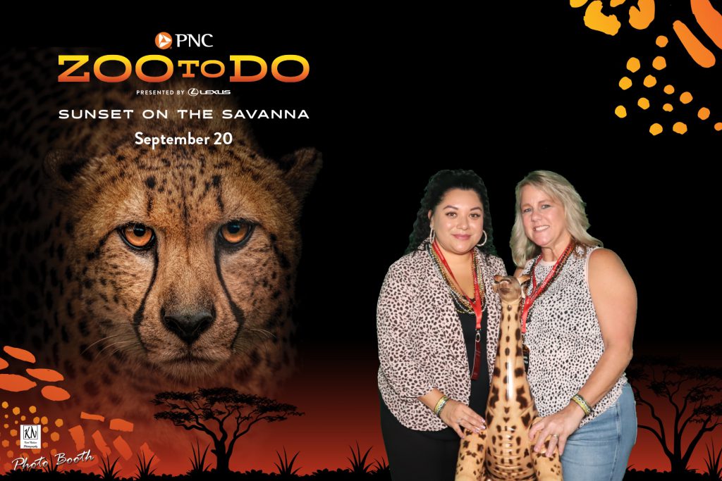 two friends holding an inflatable giraffe in a photo at the Toledo Zoo to Do