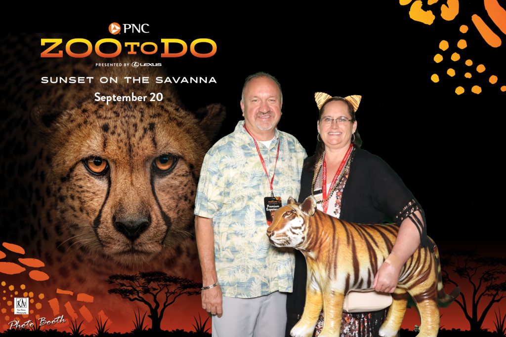 couple holding inflatable tiger in a photo at the Toledo Zoo to Do