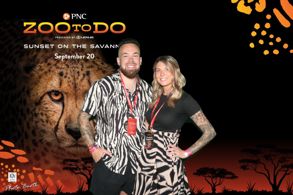 a couple showing their zoo fashion in matching zebra print outfits while posing for a photo in the VIP experience inside the Malawi Event center at the Toledo Zoo to Do 