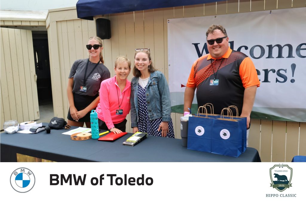 event planners from The Toledo Zoo posing for a photo at the check-in table on the patio near the pro shop at the Catawba Island Club golf course