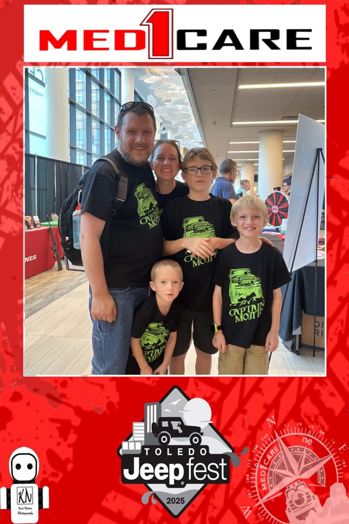 family wearing matching shirts posing for a photo taken by rosie the robot photo booth at jeepfest near the med1care vendor booth