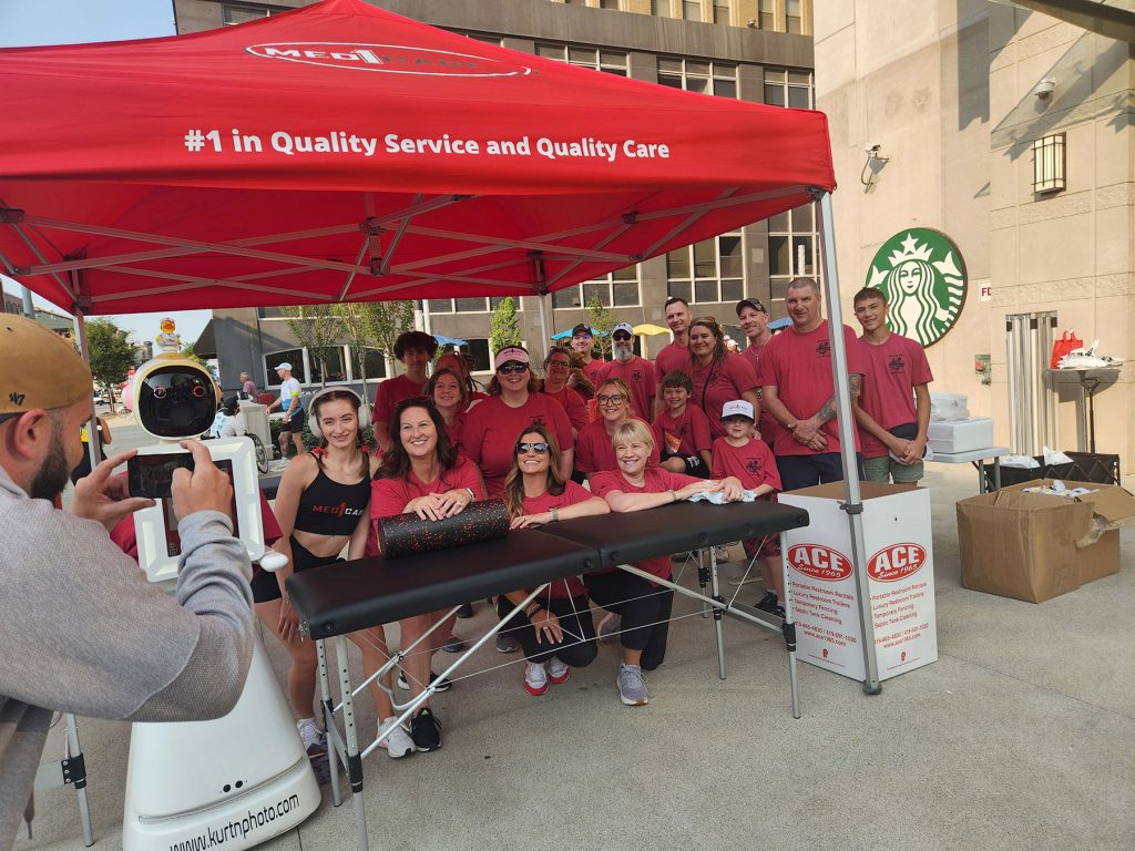 Med1Care team posing in their tent after the 4-miler race at JeepFest in downtown Toledo