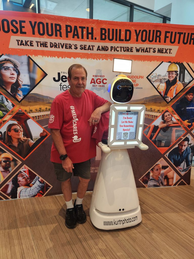 Kurt Nielsen and Rosie the Robot AI photo booth posing for a photo at Toledo Jeep Fest inside the Glass City Center