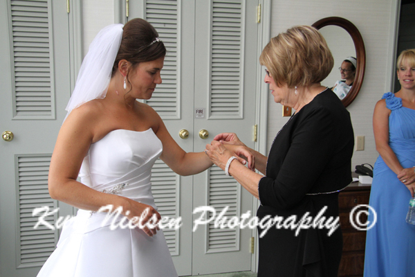 mom helping bride with bracelet