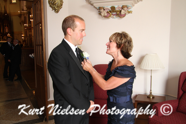mom pinning on groom's boutonniere