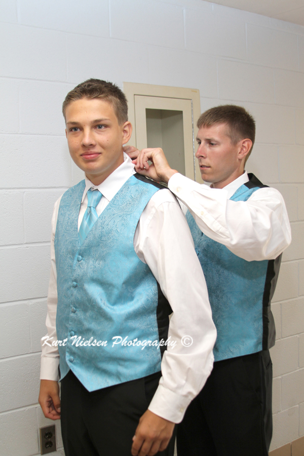 helping junior groomsman getting dressed