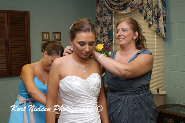 mom putting on bride's necklace