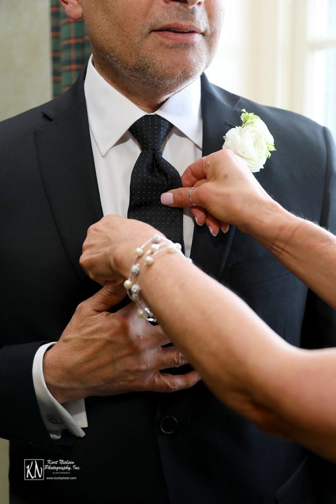 straightening the groom's tie