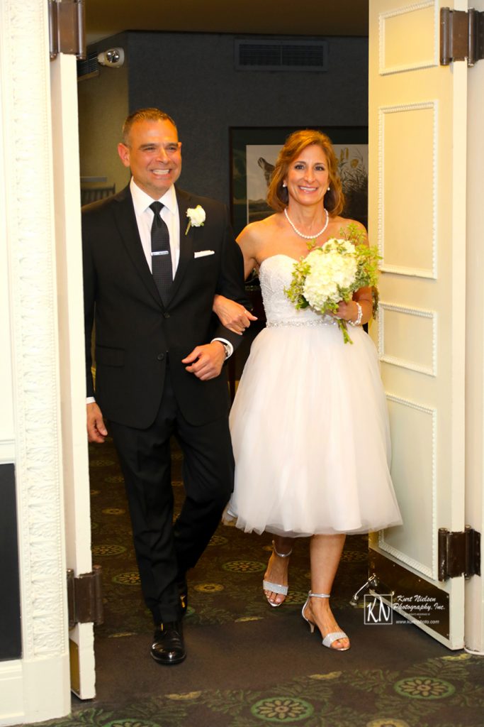 groom walking his bride down the aile