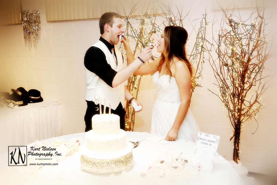 bride and groom serving the wedding cake to each other