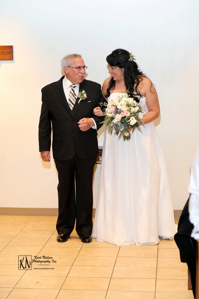 father and bride walking down the aisle