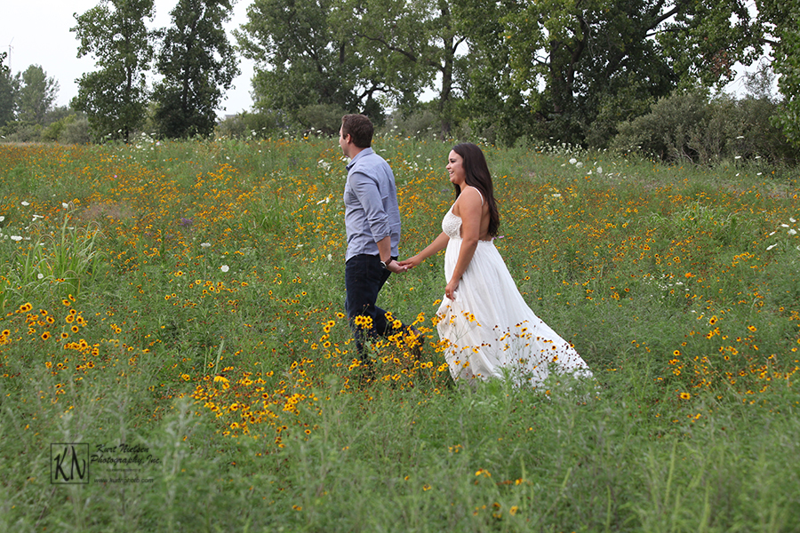 walking in a field of wildflowers for their engagement portraits