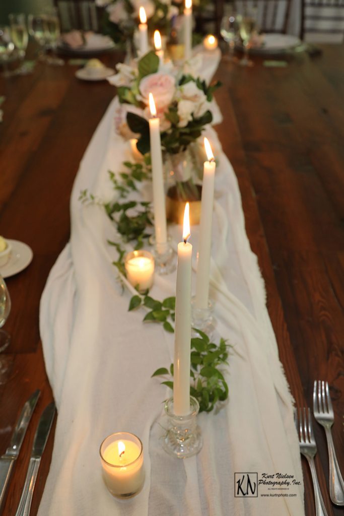 white votive and taper candles for the head table at a wedding
