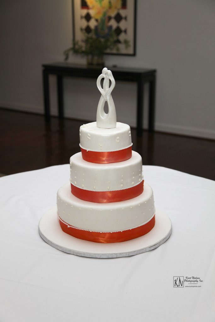 simple wedding cake with orange ribbon