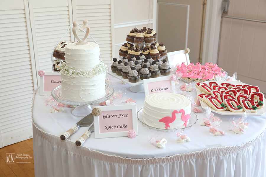 wedding cake table with cookies and cupcakes